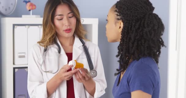 Médico Japonês Explicando Nova Prescrição Para Paciente Afro Americano — Vídeo de Stock