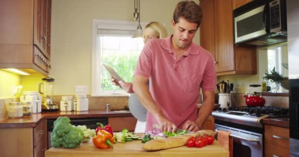 幸せな妊娠カップル一緒にキッチンでの作業 — ストック動画