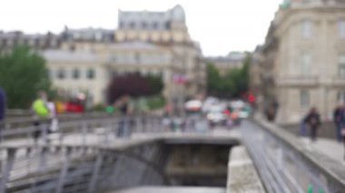 Paris 'teki Seine nehri üzerinde yaya köprüsü geçidi. Şehir ortamında yürüyen insanların odaksız arka plan plakası