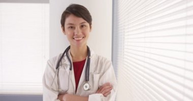Cam kenarında duran kendine güvenen Asyalı kadın doktor