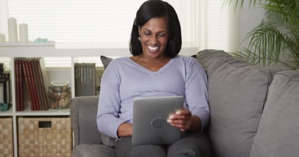 Glücklich Reif Schwarz Frau Using Tablet Internet Auf Couch — Stockvideo