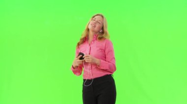İş kadını kulaklıkla müzik dinliyor ve dans ediyor.