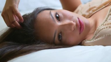 Güzel Meksikalı kadın yatakta yatıyor.