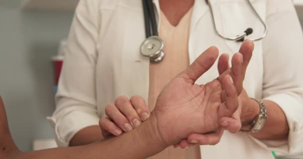 男性患者をチェックする医師のクローズアップは 彼の手首にパルス 心拍数を確認するために手首の患者に圧力をかける高齢の医師の閉鎖 — ストック動画