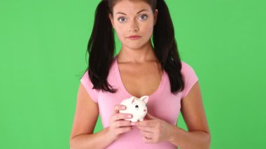 Elinde domuz kumbarası olan mutsuz genç bir kadının portresi.