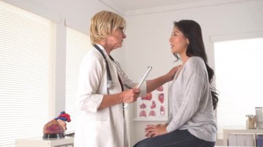 Doktor Asyalı hastayla konuşuyor.