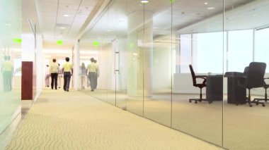 Ofis koridorunda yürüyen bir grup profesyonel.