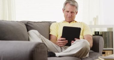 Tablet kitabı okuyan kıdemli adam.