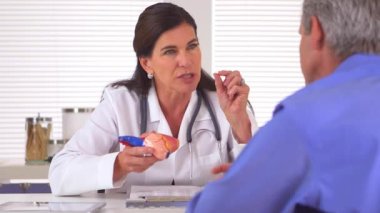 Doktor, erkek hastasına kalp ameliyatını açıklıyor.