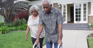 Olgun siyah çift, Walker 'la birlikte yürüyor.