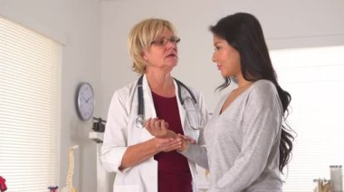 Doktor Asyalı hastanın nabzını kontrol ediyor.