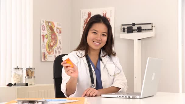 亚洲女医生面带微笑地坐在办公桌前配药的画像 — 图库视频影像