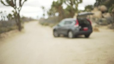 Çölde yeşil ekran ya da krom anahtar için bagajı açık bir şekilde çamurda dönen yalnız bir SUV. Birleşiklik veya anahtarlama için odak dışı veya odaklanmış çekim.