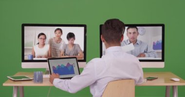 Latin ve Asyalı iş adamlarından oluşan bir grup yeşil ekranda görüntülü sohbet konferansı kullanıyor. Anahtar ya da birleşik olmak üzere yeşil ekranda.