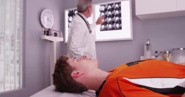 Doktor xrays değerlendirmeleri yaparken uzanarak genç spor atlet portresi