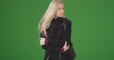 Ayakta duran seksi genç kadın, yeşil ekranda randevuyu bekliyor. Anahtar ya da birleşik olmak üzere yeşil ekranda.