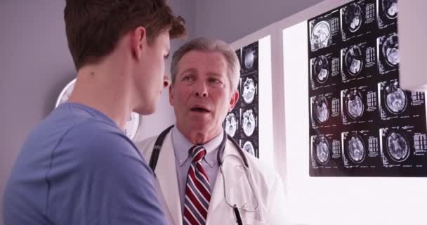 Hombre Joven Adulto Caucásico Revisando Las Radiografías Cerebrales Con Médico — Vídeo de stock