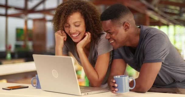 黑色千年夫妇一起工作或在咖啡店观看笔记本电脑上的视频 餐馆或咖啡店里的非裔美国男女都在喝咖啡和使用电脑 — 图库视频影像