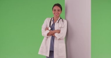 Mutlu gülümseyen İspanyol profesyonel kadın yeşil ekranda birleşim için. Krom anahtarlama için kollarını birleştiren yeşil ekran üzerinde laboratuvar önlüklü kadın doktor ya da dişçi. 4k