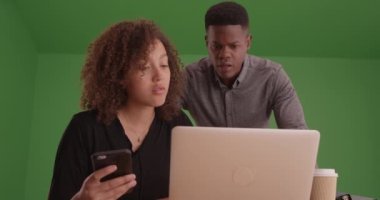 Genç siyahlar yeşil ekranda dizüstü bilgisayarlarıyla çalışıyorlar. Anahtar ya da birleşik olmak üzere yeşil ekranda.