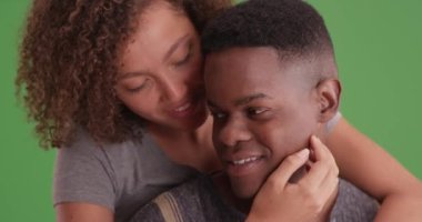 Mutlu gülümseyen Afrikalı Amerikalı kadın ve erkek her birini yeşil ekranda kucaklıyor. Anahtar ya da birleşik olmak üzere yeşil ekranda.