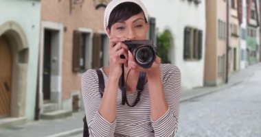 Venedik İtalya caddesinde fotoğraf çeken kameralı bir kadın. 20 'li yaşlarda tatilde olan siyah bir turist.