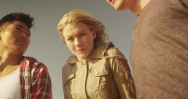 Bir grup arkadaş sahile doğru okyanusa bakıyorlar.