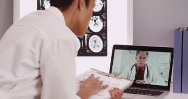 Olgun erkek doktor, genç bayan doktorla görüntülü sohbet ediyor.