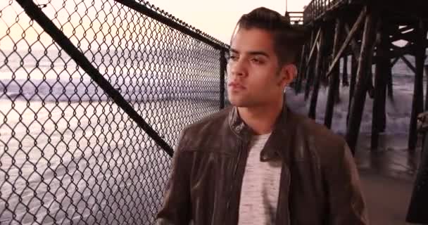Modischer Hispanischer Millennial Mann Der Unter Einer Seebrücke Strand Steht — Stockvideo