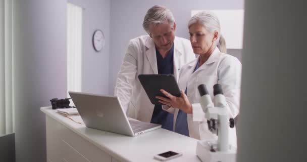 Dois Médicos Seniores Olhando Para Tablet Laptop — Vídeo de Stock