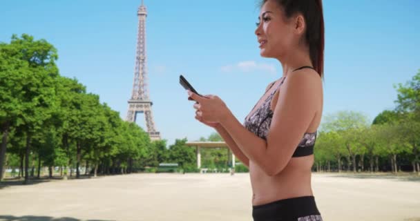Boldog Ázsiai Ruhákat Futtat Sms Eket Mobiltelefonon Párizsban Egy Kocog — Stock videók