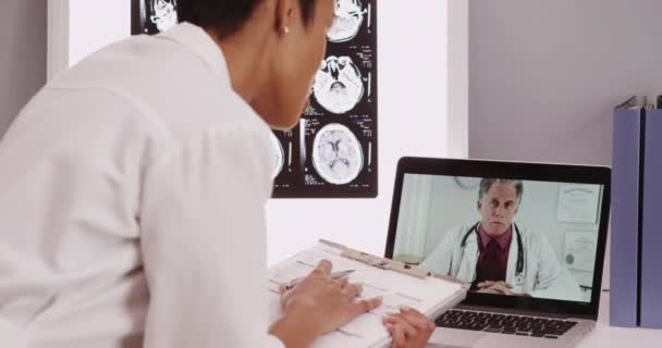 Maduro Médico Masculino Video Chat Con Joven Médico — Vídeos de Stock