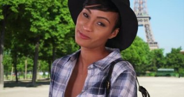 Büyüleyici Afrikalı kadın Paris 'teki Eyfel Kulesi' nin yakınındaki kamerada neşeyle gülümsüyor. Paris, Fransa 'da tatilde olan muhteşem etnik bayan iyi vakit geçiriyor. 4k