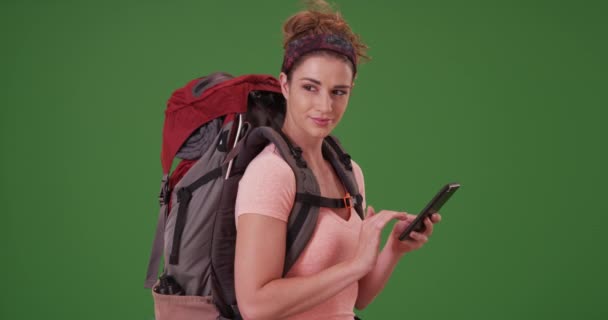 年轻女性徒步旅行者使用智能手机在绿色屏幕上查找路径图 在绿色屏幕上键入或合成 — 图库视频影像