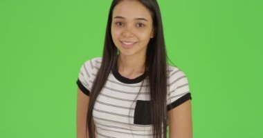 Genç bir üniversiteli kız yeşil ekranda poz veriyor. Anahtar ya da birleşik olmak üzere yeşil ekranda.