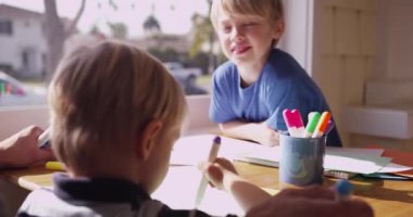 Genç beyaz çocuk kardeşine bakıyor.