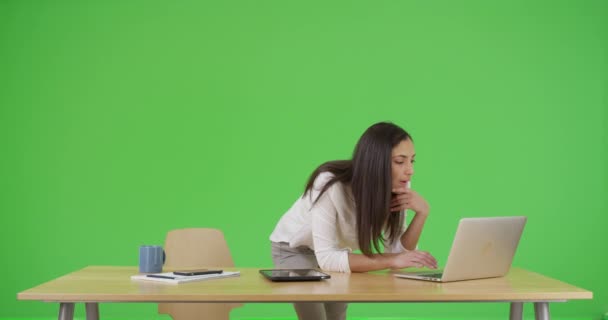 ヒスパニック系の女性は緑の画面で仕事で彼女のラップトップを使用しています 緑の画面でキーまたは構成されます — ストック動画