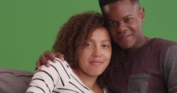 一对黑人夫妇在他们的沙发上的绿色屏幕上摆出一副肖像的姿势 在绿色屏幕上键入或合成 — 图库视频影像