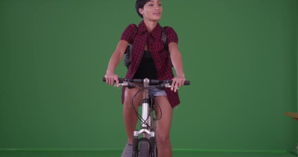 緑の画面を見回すカメラに向かって自転車に乗っている千年前の黒人女性 緑の画面でキーまたは構成されます — ストック動画