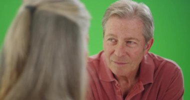 Yaşlı beyaz adam bayan arkadaşıyla konuşuyor.