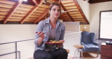 Mutlu kadın evde yemeğini yiyor. 20 'li yaşlarda sıradan bir kadın, yemeğinin tadını çıkarıyor..