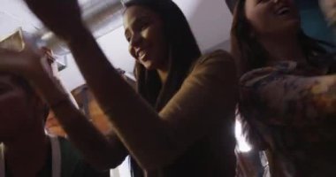 Hippi karışık bir grup arkadaş çılgın şehir dans partisinde alkış ve dans ediyor.