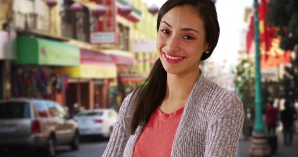 在中国的一个小镇上 一个西班牙裔女孩摆出一副画像的姿势 在旧金山 一个拉丁女人看着摄像机笑了 — 图库视频影像