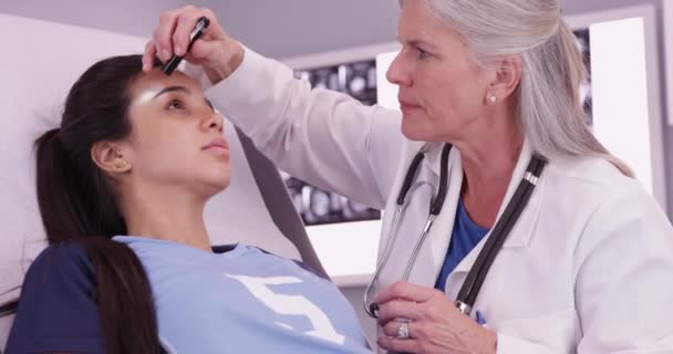 Mid Aged Caucasian Doctor Reviewing Female Hispanic Athlete Head Trauma — Stock Video