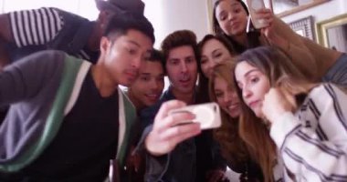 Genç hippi arkadaşlar partide telefonda selfie çekerken eğleniyorlar.