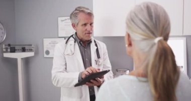 Kafkasyalı kıdemli doktor tablet kullanıyor.