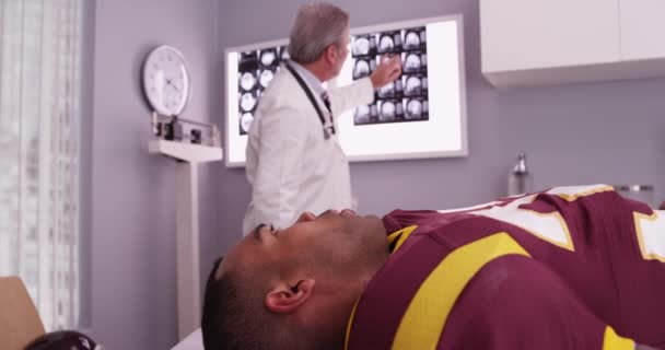 Medico Caucasico Senior Che Rivede Radiografie Del Cranio Dell Atleta — Video Stock