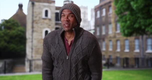 Ung Afrikansk Man Besöker England Klädd Vinterkläder Stående Utanför Livlig — Stockvideo