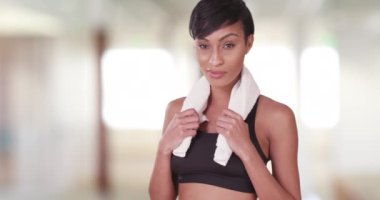 Spor salonundaki atletik kadın idmandan sonra boynunda havluyla. 20 'li yaşlarda sağlıklı bir siyah milenyum..