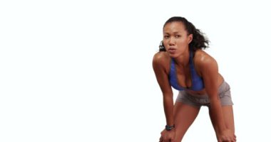 Filipinli kadın koşucu beyaz arka planda kopyalama ile fitness takip cihazını kontrol ediyor. Stüdyoda koşuya ara veren spor elbiseli kadın, 4K